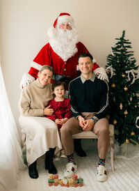 An expat family living in the Netherlands sit with Santa Claus for a photo. 