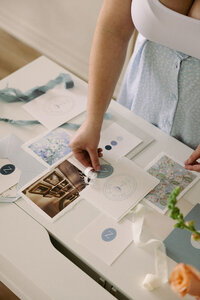 Wedding planner creating a wedding invitation suite flat lay with dainty details and ribbons