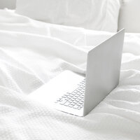 silver laptop on white linens