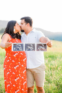 expecting parents holding up an ultrasounds picture for maternity photos in st. george