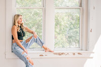 Personal branding session of woman sitting on window ledge in studio in New Braunfels, Texas.