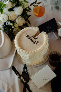 A small wedding cake with a piece taken out of it