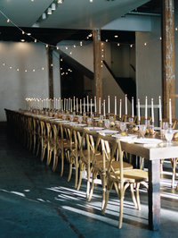 wood farm table with candlesticks and string lights