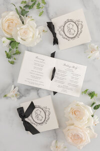 Wedding ceremony programs tied with black ribbon and custom monogram.