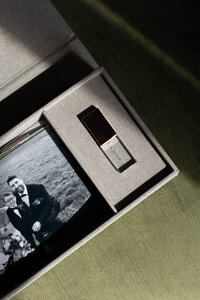The inside of a linen keepsake box is displayed revealing an etched-glass USB and luxury prints.