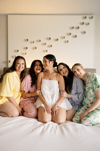 bridal party sitting on bed reading newspaper by wedding photographer tampa