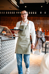 Mitarbeiter mit Tablett in der Hand im Restaurant LOTTA.