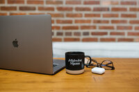 Coffee cup with words 'midwest mama' on it next to laptop