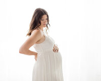 mom in white boho dress for maternity photoshoot