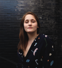 woman standing in fron to f dark wall