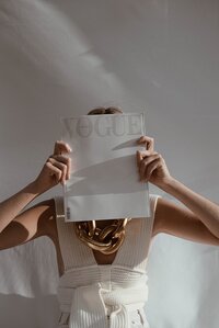 woman holding vogue magazine in front of her face