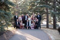 Bride and groom stand with their bridal party in some trees. Captured by Amanda Jordan Photography.