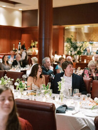 Candlelit rehearsal dinner with guests enjoying an intimate setting at a high-end Washington DC steakhouse, captured by a multi-day wedding photographer