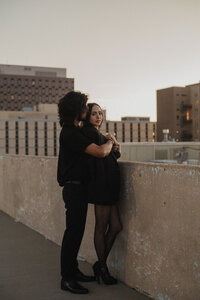 Couple posing on rooftop holding each other in albuquerque.