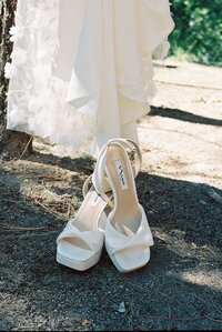 bridal shoes with pearls and heels sitting outside in the sunlight