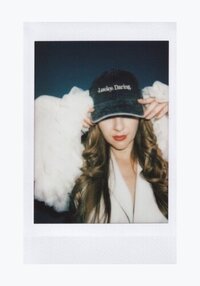 Polaroid of  Sasha Fedunchak wearing cap and looking down