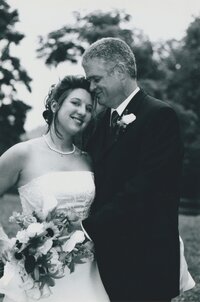 Black and white photo of married couple with bride facing the camera smiling- Romero Album Design