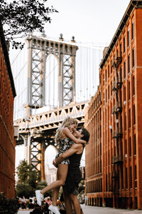 Couple kissing under a bridge