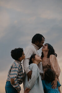 Outdoor family photoshoot in Omaha park during golden hour – capturing candid, heartfelt moments.