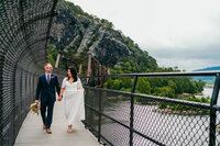 Bride and groom walk hand in hand on the bridge in Harpers Ferry during their Elopement