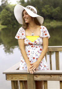 Senior at a lake wearing sun hat