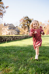 blue bell pennsylvania family photographer childrens photo session little girl running through grass