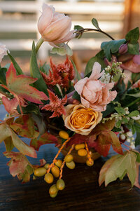 A modern bride holding her brightly colored bouquet for a close up