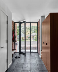 Entrance to home with wooden cabinets and black tiled floors