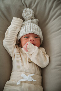 Newborn lifestyle photo of baby waking up in bed at home in the Hudson Valley