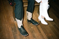 bride and groom's western boots hanging off a pool table