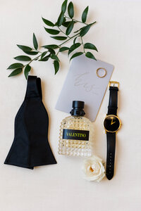 classic-groom-detail-shot-including-bow-tie-cologne-watch-vow-book