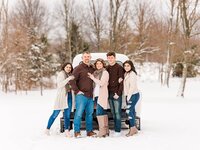 Family standing by a white truck outdoors in the snow in North East, PA.