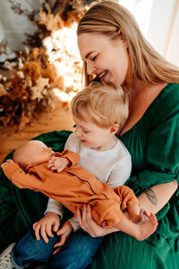 Mother and son hold newborn baby