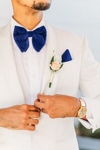 Groom buttoning jacket at Ashton Gardens in Atlanta