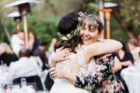 bride hugging a smiling wedding guest