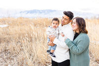 Family with young boy share a cute moment while showing off the wintery landscape of Saratoga Springs
