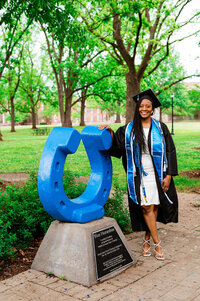 College senior standing beside the MTSU horseshoe