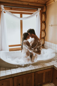 man and woman embracing in a bubble bath