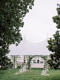 Private estate wedding celebration under a luxury sailcloth tent with floral-lined entrance, captured by a multi-day estate wedding photographer