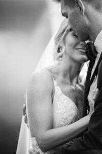 Black and white photo of a bride hugging a groom