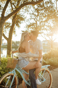 Couple kisses on top of bicycle