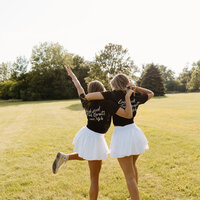 Two people with their arms around each other standing in a field
