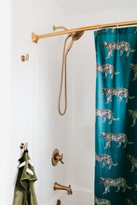 Bathroom Remodel and Design Details with Gold Fixtures and Blue Pattern Shower Curtain