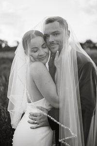 Detail shot of the bride and groom hiding under her veil photographed by Philadelphia wedding photographer.