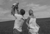 A new family having fun while carrying their child