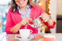 Woman pouring tea into tea cup