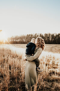 Autumn mama and me family photoshoot in Oxford PA during sunset in a tall grassy field wearing dress by Joyfolie