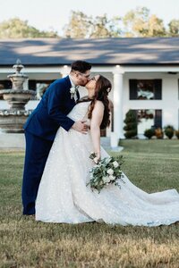 Jared dips Lexi for a kiss in front of their wedding venue