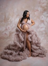 Atlanta maternity photographer photographing mom in a mauve ruffled dress showing off her baby bump.