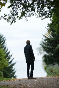 man standing on a road looking into the distance